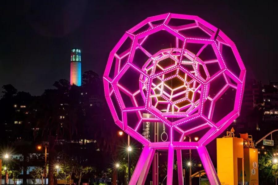 Buckyball glows in the foreground while Coit Tower shines in the distance.